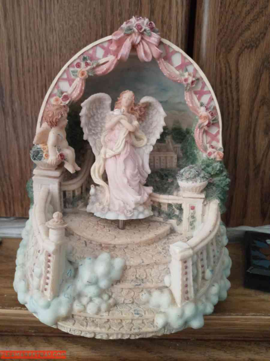 a music statue that sings with an angel on top