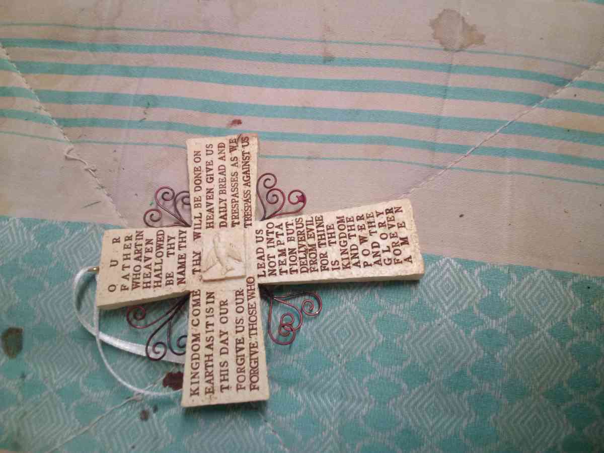 a religious wall hanging and two pairs of hand made earrings