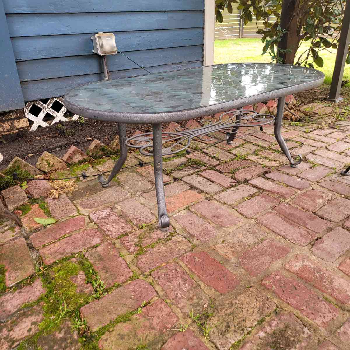 Oval outdoor glass coffee table with metal trim - Shreveport, Louisiana - FleaMarketBay
