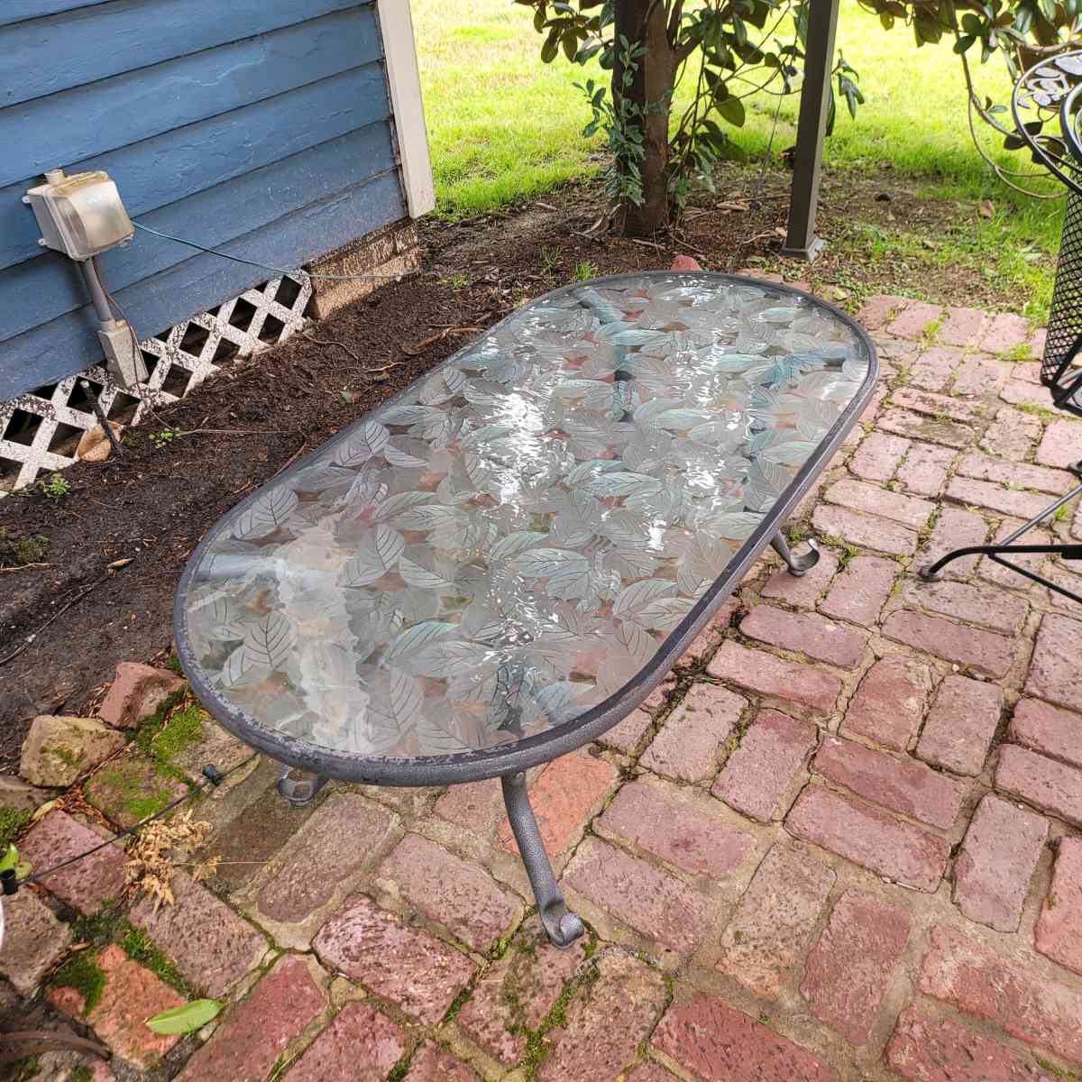 Oval outdoor glass coffee table with metal trim - Shreveport, Louisiana - FleaMarketBay