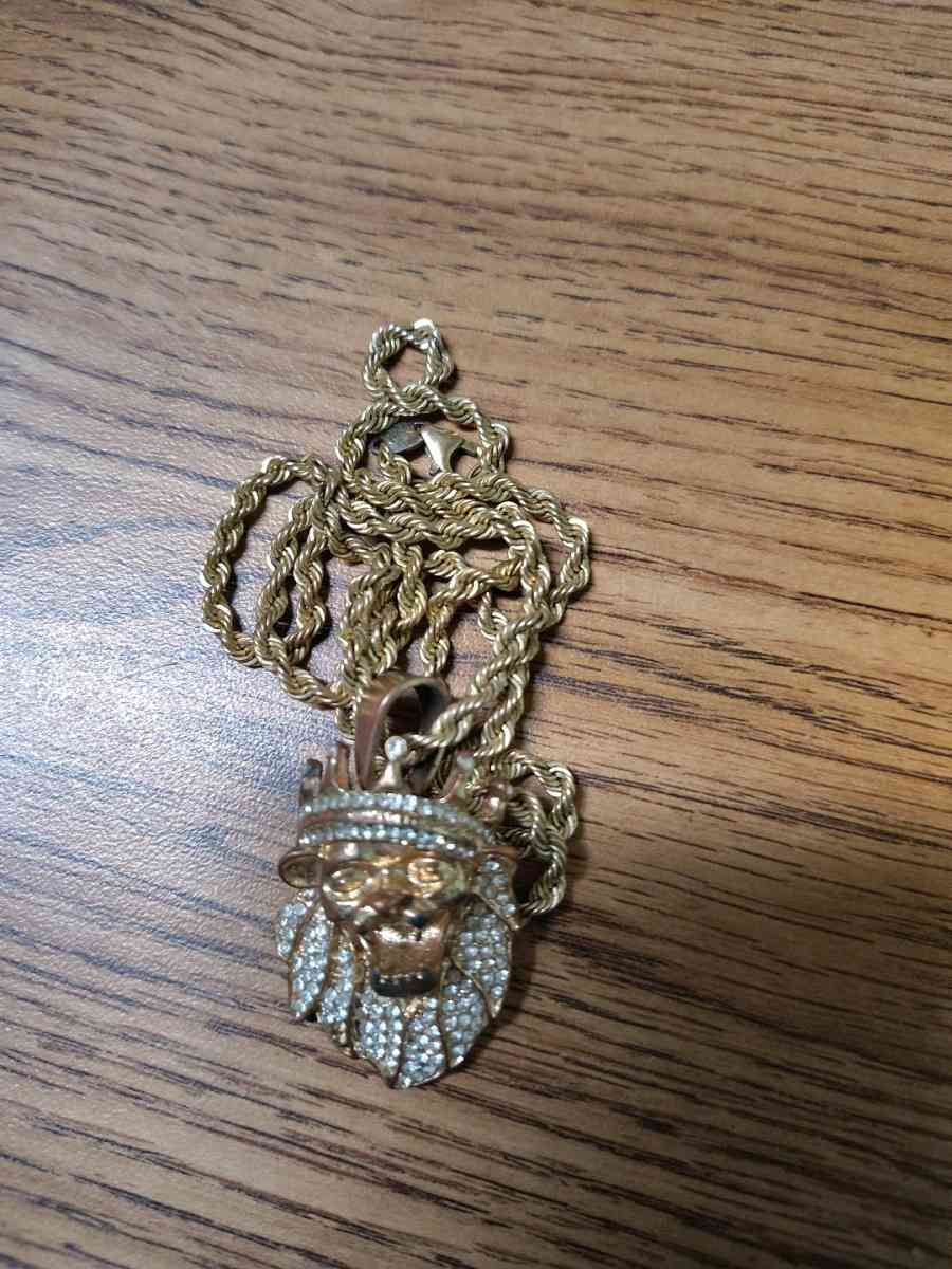 This is a goldtoned lion head pendant with a crown